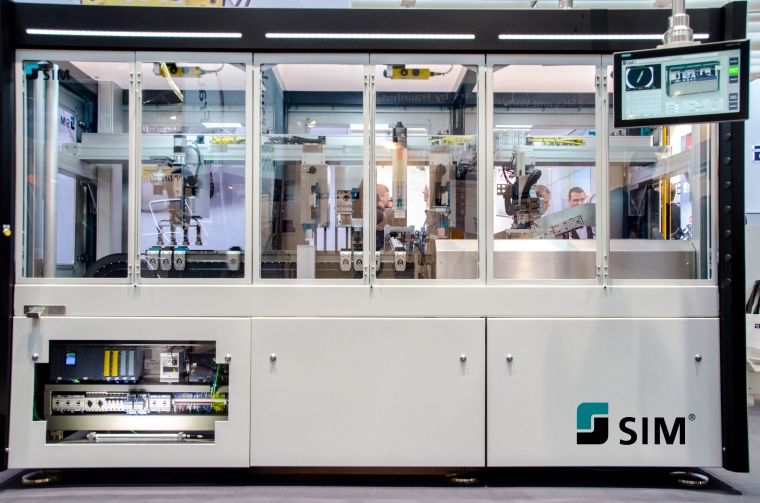 SIM Montage- und Prüfanlage mit Bedieneinheit (rechts) und Durchblick auf...