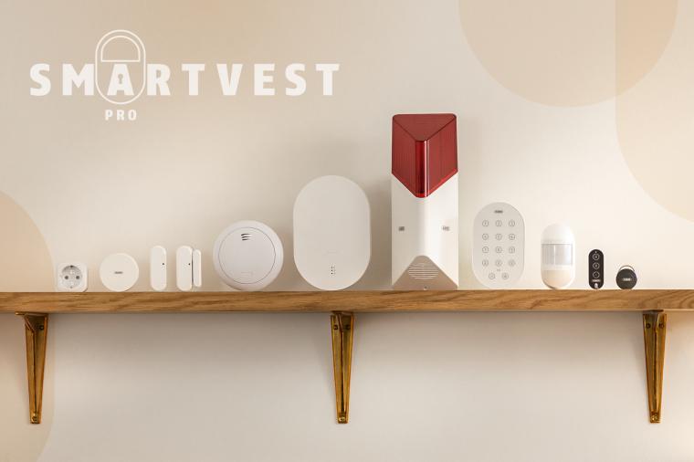 Komponenten der Funkalarmanlage Smartvest Pro Von Abus auf einem Holzregal vor...