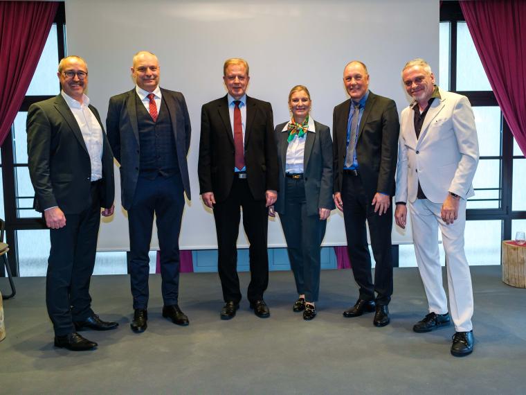 Fünf Herren und eine Dame vor einer Leinwand