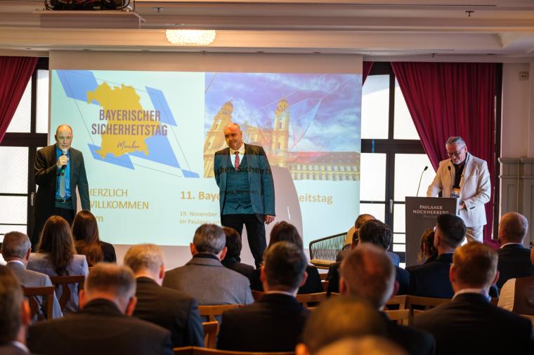 Drei Männer vor einem Auditorium