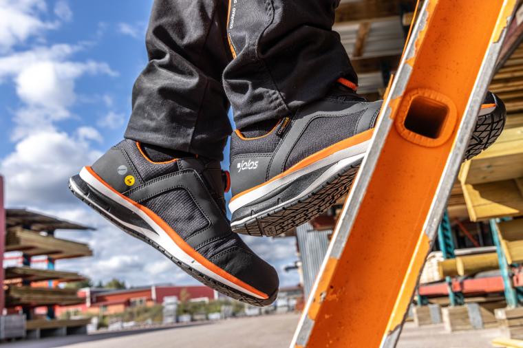 Sicherheitsschuhe mit rutschfester Sohle auf einer Leiter im Arbeitseinsatz –...