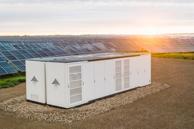 Large battery storage in front of field with photovoltaic systems