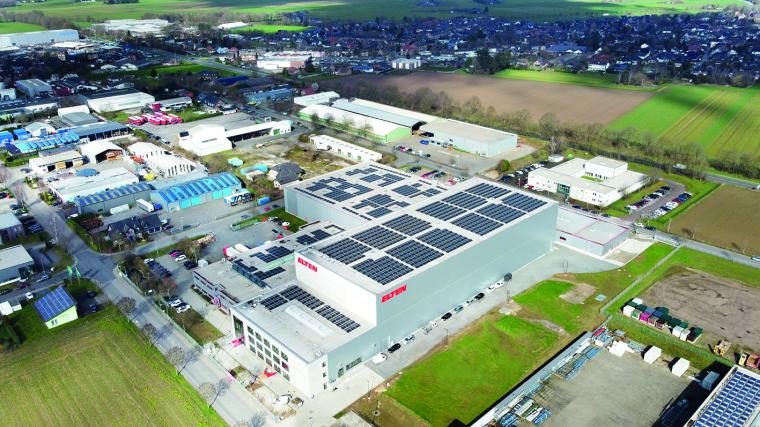 Aerial view of a large logistics and industrial building with solar panels on...