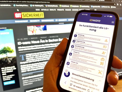 Smartphone mit Monitor im Hintergrund