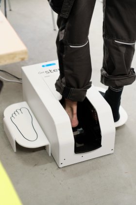 Person stellt den Fuß in ein Gerät zur digitalen 3D Fußvermessung